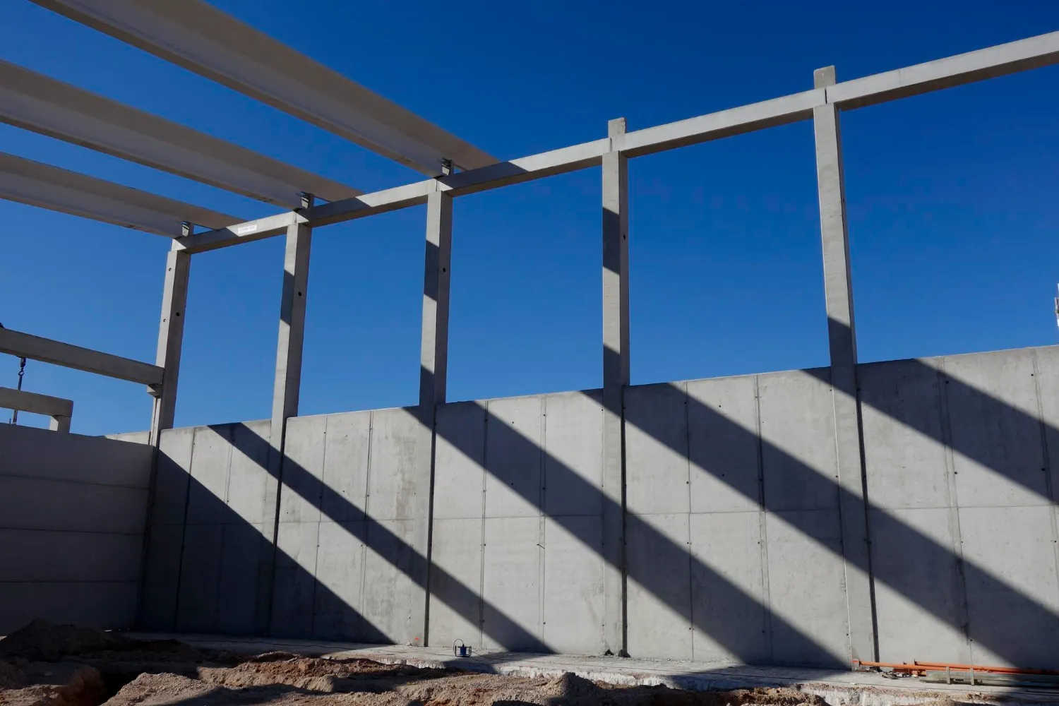 Prefabrykowane elementy betonowe podczas budowy hali przemysłowej.