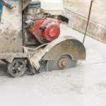 Cięcie betonowej posadzki metodą diamentową z wykorzystaniem przecinarki i chłodzenia wodnego.